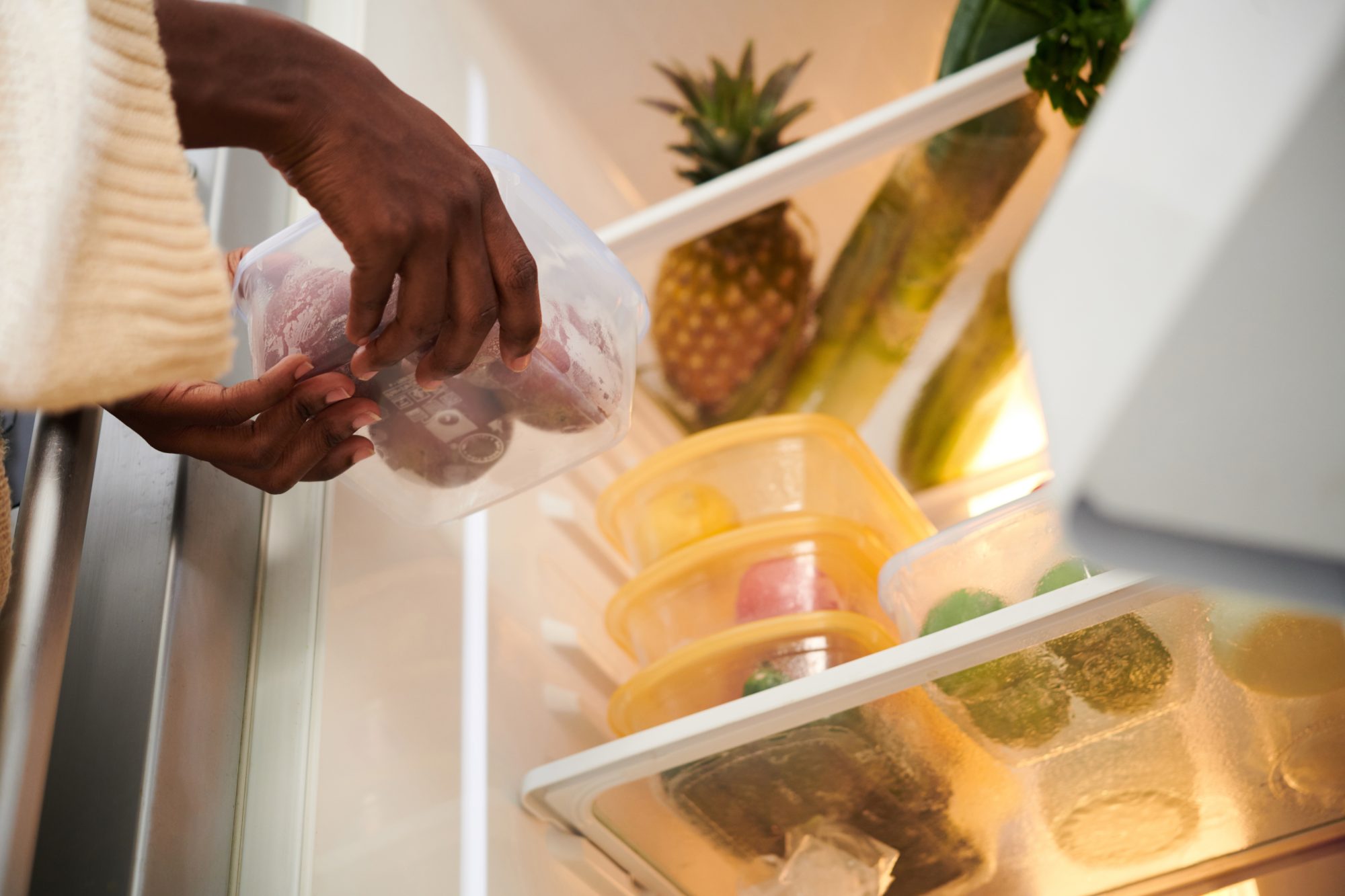 Alimentos sendo colocados na geladeira. Falta de luz e água.